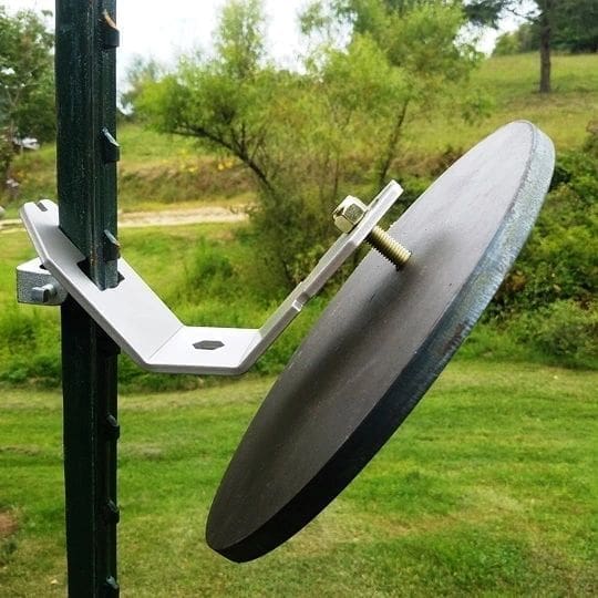 Hang Fast Standard T Post target hanger holding a 12 inch round AR500 steel plate with a single bolt.